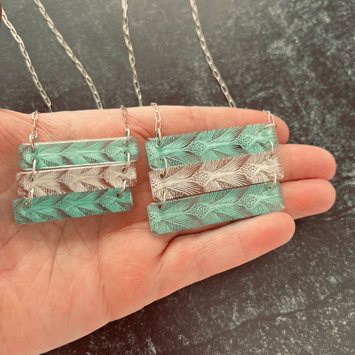 Sea Turtle Pattern 3 bar necklace in alternating green and white.  Shown in hand to see size comparison and details.