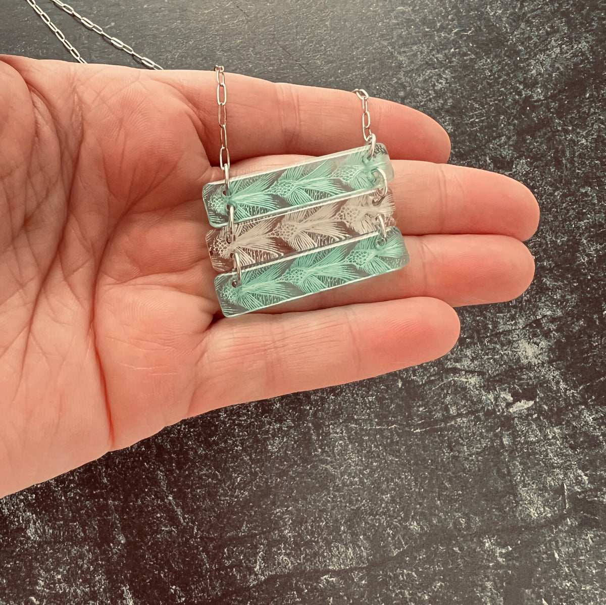 Sea Turtle Pattern 3 bar necklace in alternating green and white.  Shown in small size in hand for details