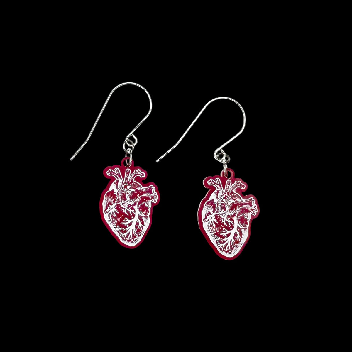 Red Anatomical Heart Earrings on black background